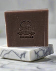 Handcrafted Lavender Bar Soap displayed on marble dish beside natural lavender sprigs