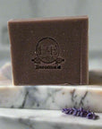 Lavender bar soap on a marble surface with lavender sprigs.