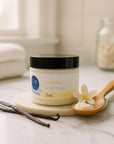 2 oz jar of whipped vanilla body butter cream with vanilla pods and flower on marble countertop for deep hydration and sensitive skin care