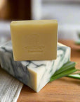 Lemongrass Bar Soap for sensitive skin, natural and chemical-free, on a wooden surface with green leaves.