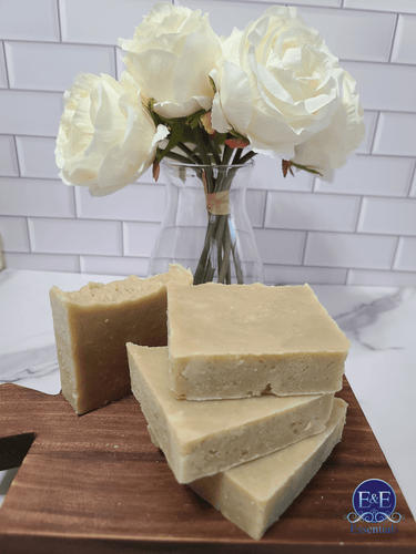 Yarrow and witch hazel soap bars with white roses in the background.
