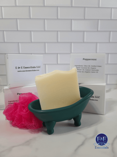 Peppermint bar soap in a decorative soap dish with packaging and pink loofah.