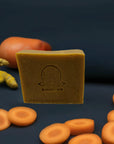 Carrot & Turmeric Bar Soap accompanied by carrots and turmeric roots