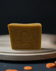 Close-up of Carrot & Turmeric Bar Soap with carrot garnish