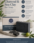 Charcoal and sea clay bar soap with packaging on a stone surface, surrounded by greenery.
