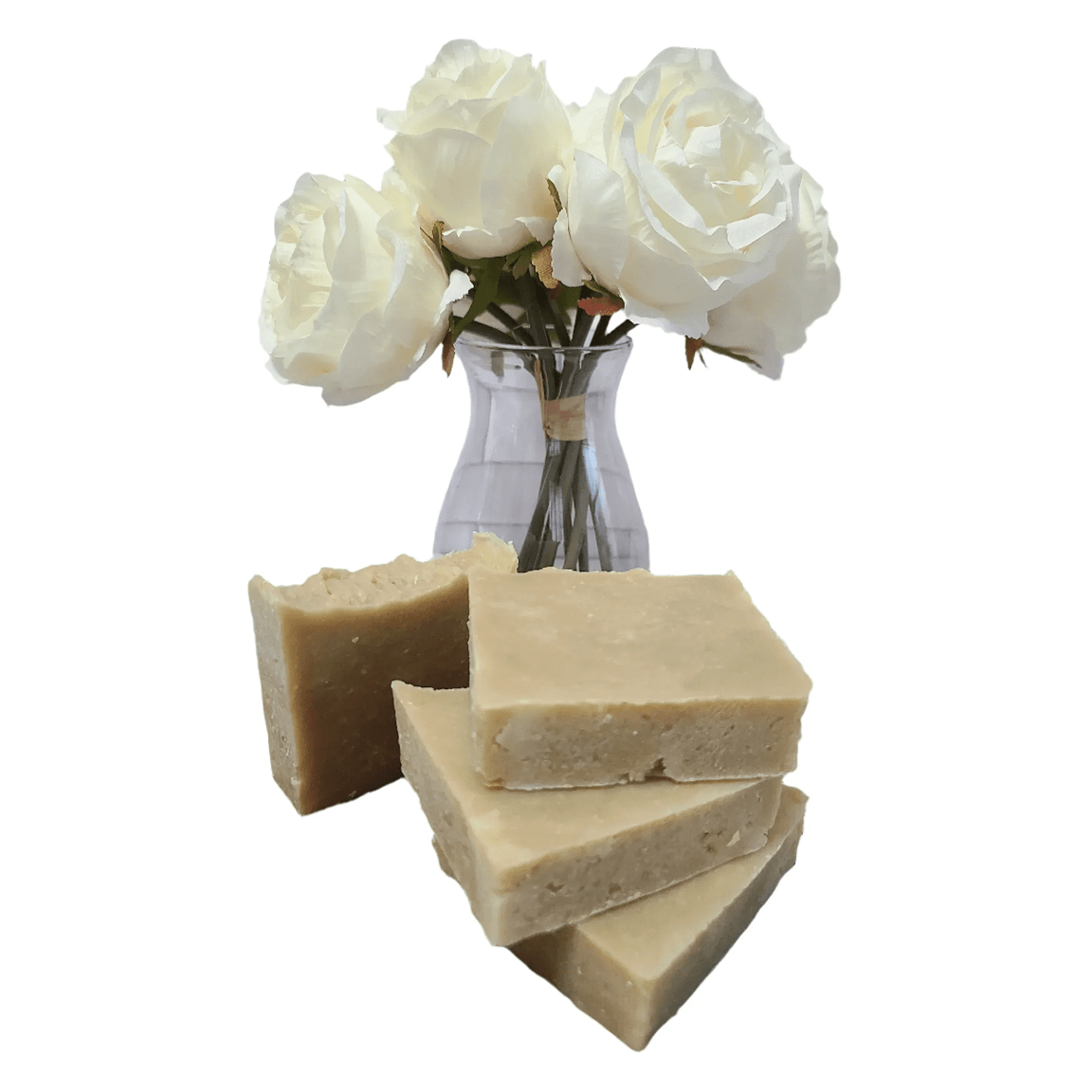 Three bars of soap stacked with a clear vase containing white roses on a white background