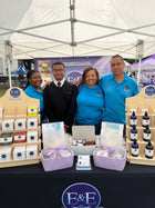 Family standing in front of an E&E Essentials brand display at an event.