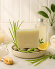 Lemongrass bar soap for sensitive skin with natural ingredients, refreshing scent, and moisturizing properties displayed with green leaves and lemon wedge.