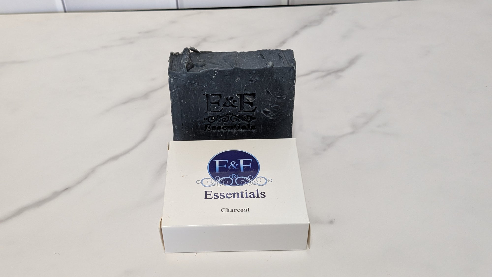 Charcoal bar soap with a branded label on a white surface