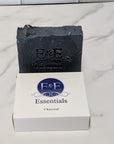 Charcoal bar soap with a branded label on a white surface