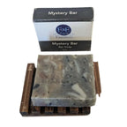 Mystery Bar Soap with natural ingredients on wooden soap dish, packaged in branded box.