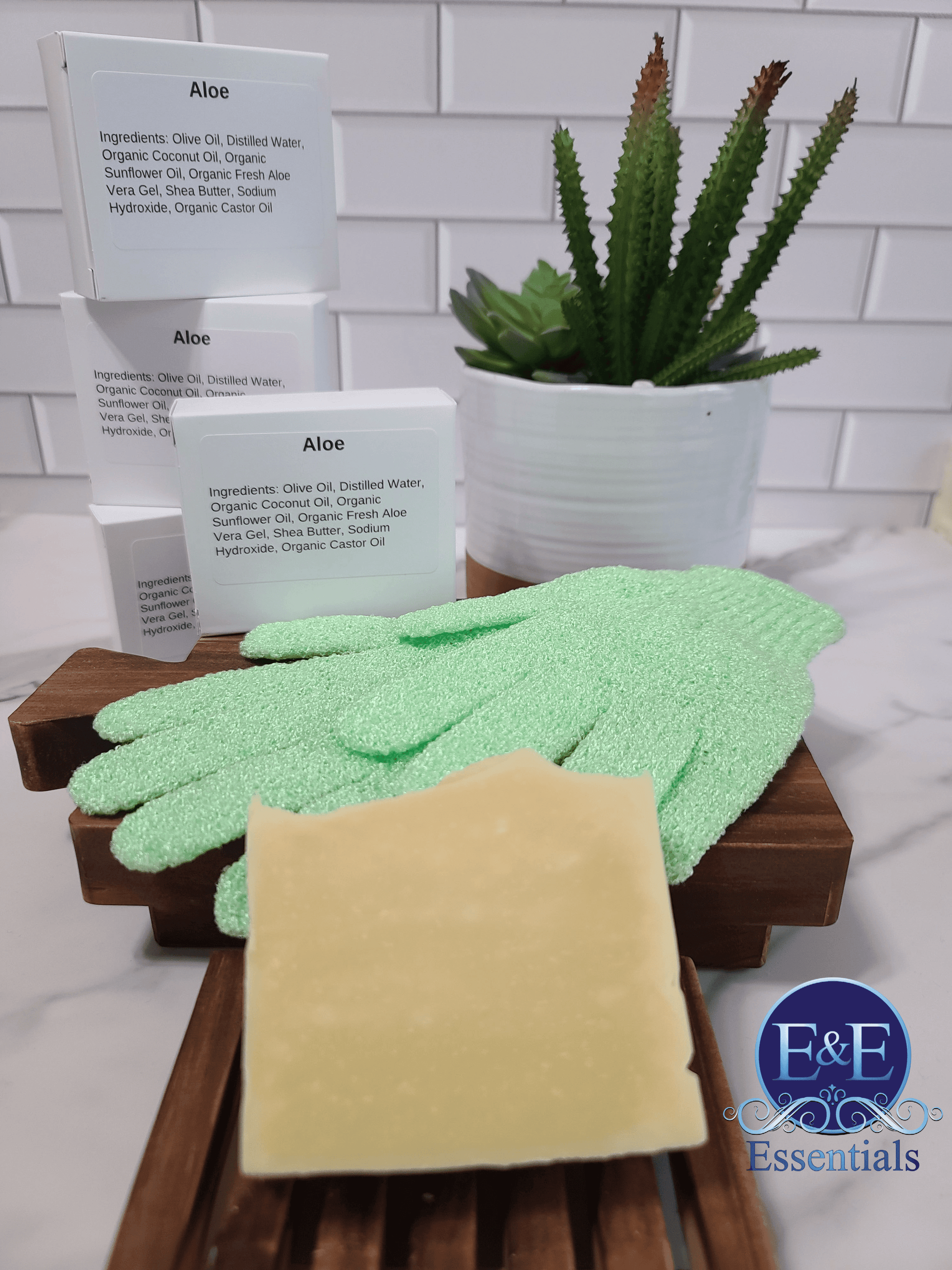 Aloe & Shea Butter Bar Soap accompanied by gloves and a small cactus on a bathroom surface