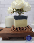 Charcoal & Sea Clay Bar Soap displayed on a wooden tray with floral accents