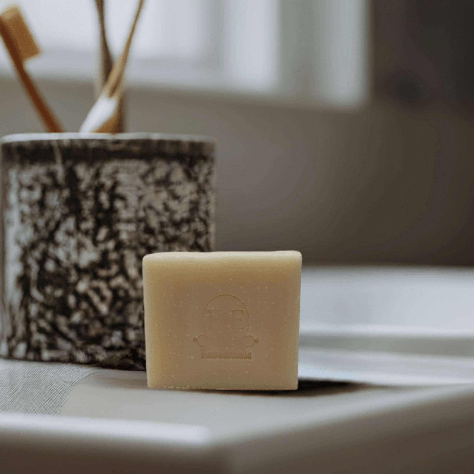 Bar of Frankincense soap placed beside a toothbrush on a bathroom countertop