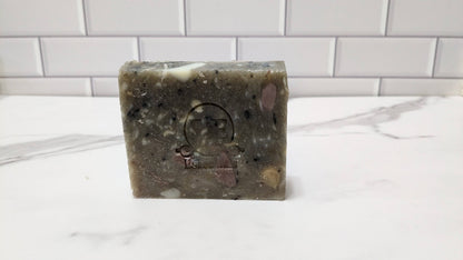 Mystery Bar Soap accompanied by a wooden soap dish