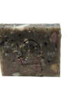 Mystery Bar Soap with an embossed design resting on a wooden slab