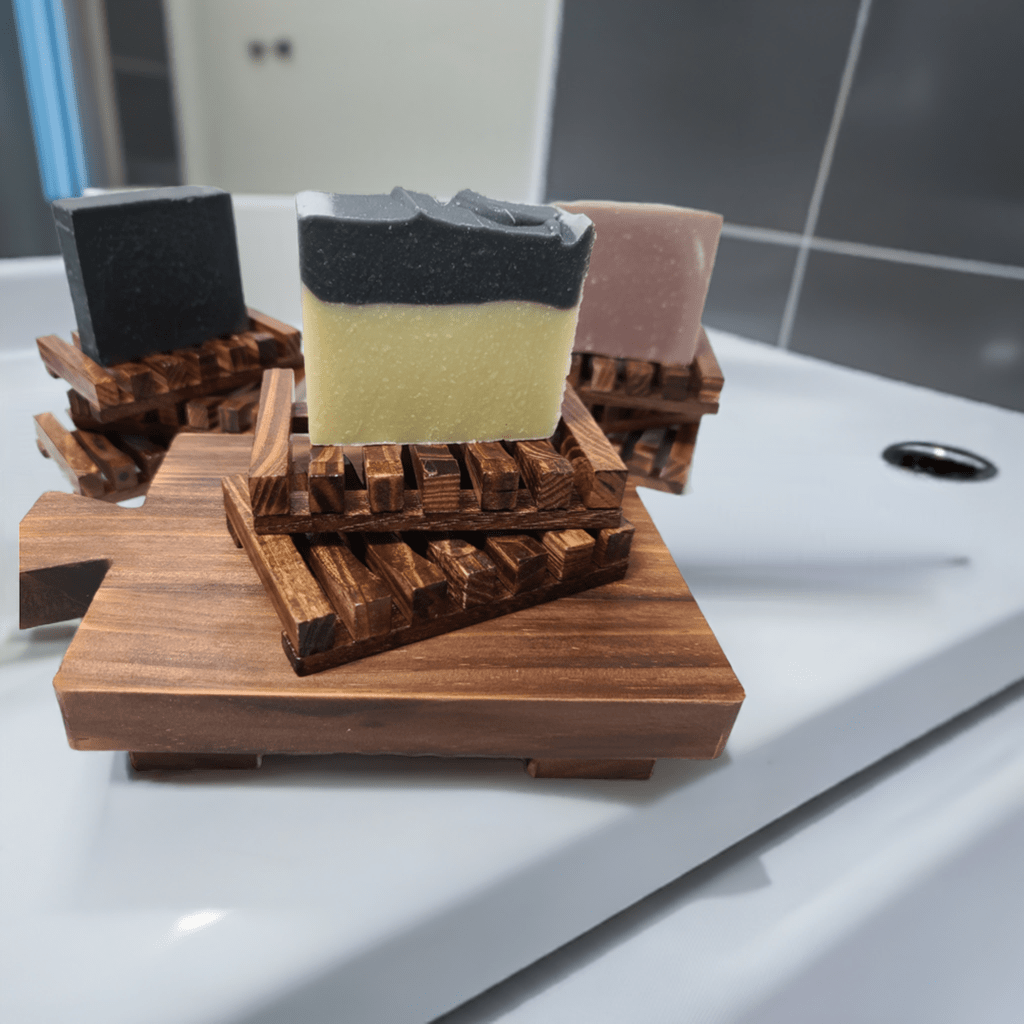 Single soap bar placed on a wooden soap dish by the sink