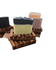 Multiple soap bars arranged on a slatted wooden dish in a bathroom setting