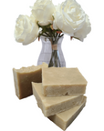 Three slices of Yarrow & Witch Hazel Facial Bar Soap displayed on a wooden cutting board