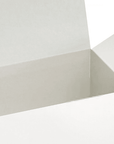 White gift box with its lid ajar against a white backdrop