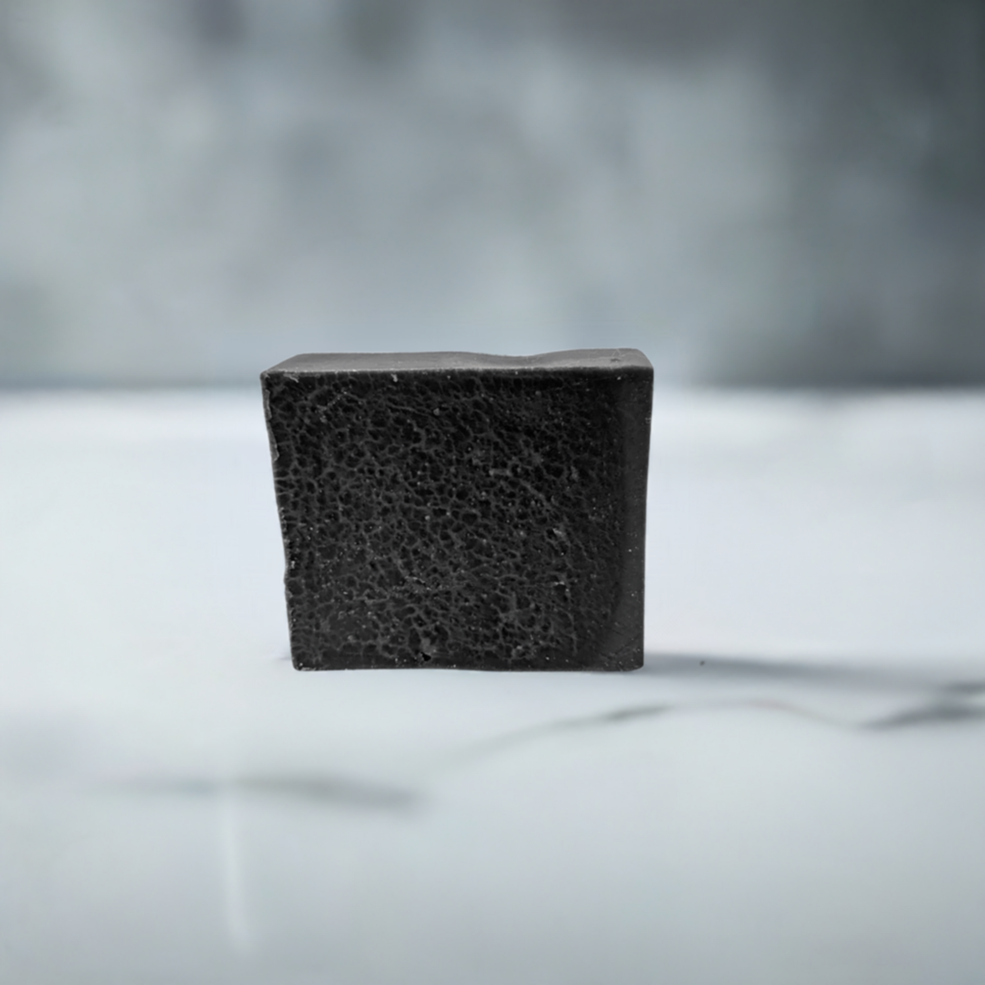 Close-up of charcoal bar soap on a pristine white countertop