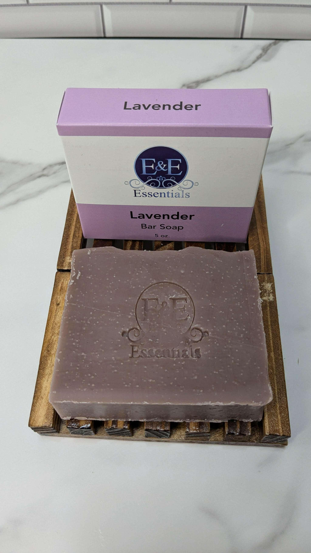 Lavender bar soap with packaging on a wooden soap dish, promoting stress relief and aromatherapy benefits.