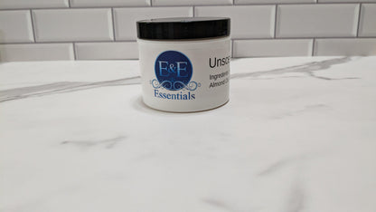 Open container of unscented body butter on a countertop